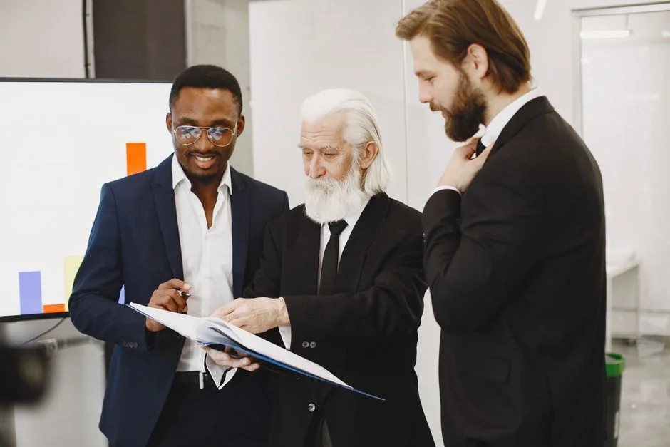 A team examining financial charts and digital data on tablets in an office environment.